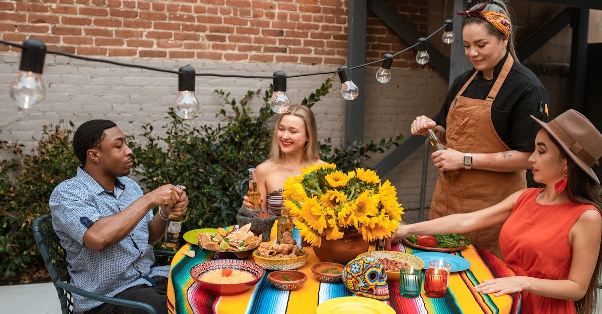 Friends gathered at an outdoor dining table with food and string lights